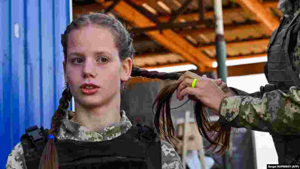 A female Ukrainian cadet, wearing a new military uniform, has her hair braided. &nbsp;