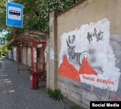 A protest mural with the words "Meat-grinder politics" in Russia's Kaluga region