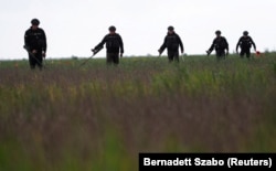 Members of Ukraine's State of Emergency Service inspect an area for mines and unexploded shells near the village of Blahodatne, in the Mykolayiv region, on May 10.