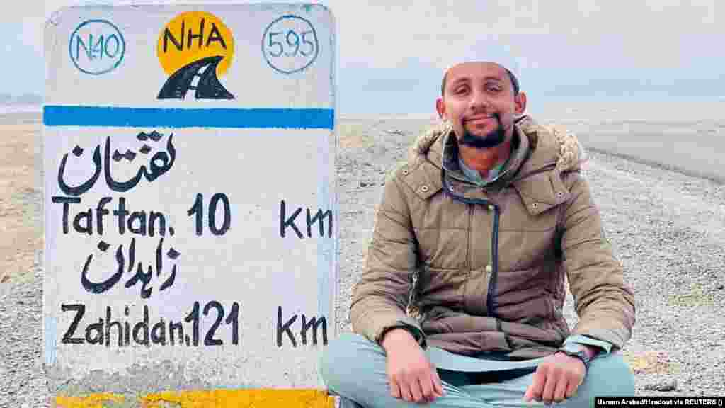 Pakistani student Usman Arshad rests next to a road sign near Quetta in this undated photo. Arshad&#39;s six-month journey on foot to reach the holy city of Mecca took him across Pakistan, Iran, the United Arab Emirates, and Saudi Arabia -- nearly 4,000 kilometers. &nbsp;