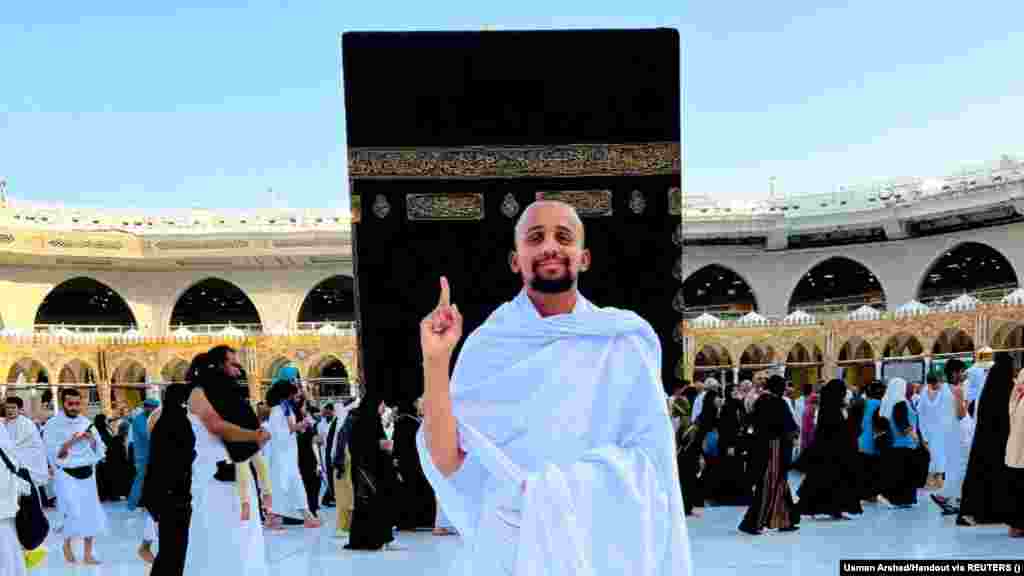 After enduring rejected visas, bad weather, and difficult sleeping arrangements along the 4,000-kilometer, six-month journey, a smiling Arshad stands in the center of the Great Mosque of Mecca, with the Kaaba standing behind him.