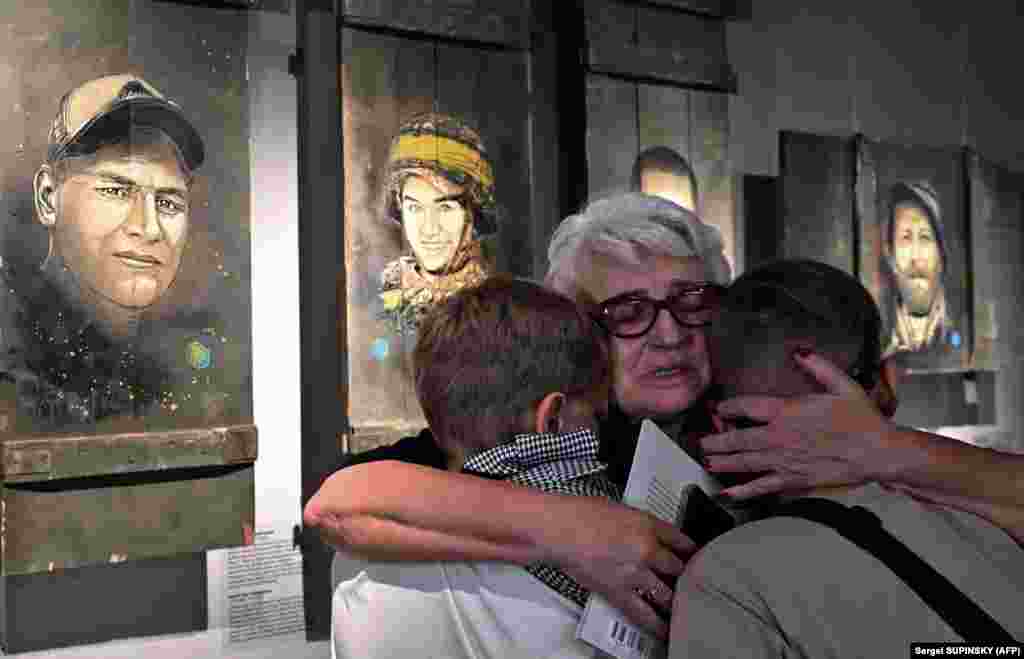 Relatives of deceased Ukrainian soldiers react to some of the portraits painted by French street artist Christian Guemy. His exhibition Guerre En Ukraine (War in Ukraine) opened in the Exhibition Center of Kyiv&#39;s War Museum on July 8.&nbsp;