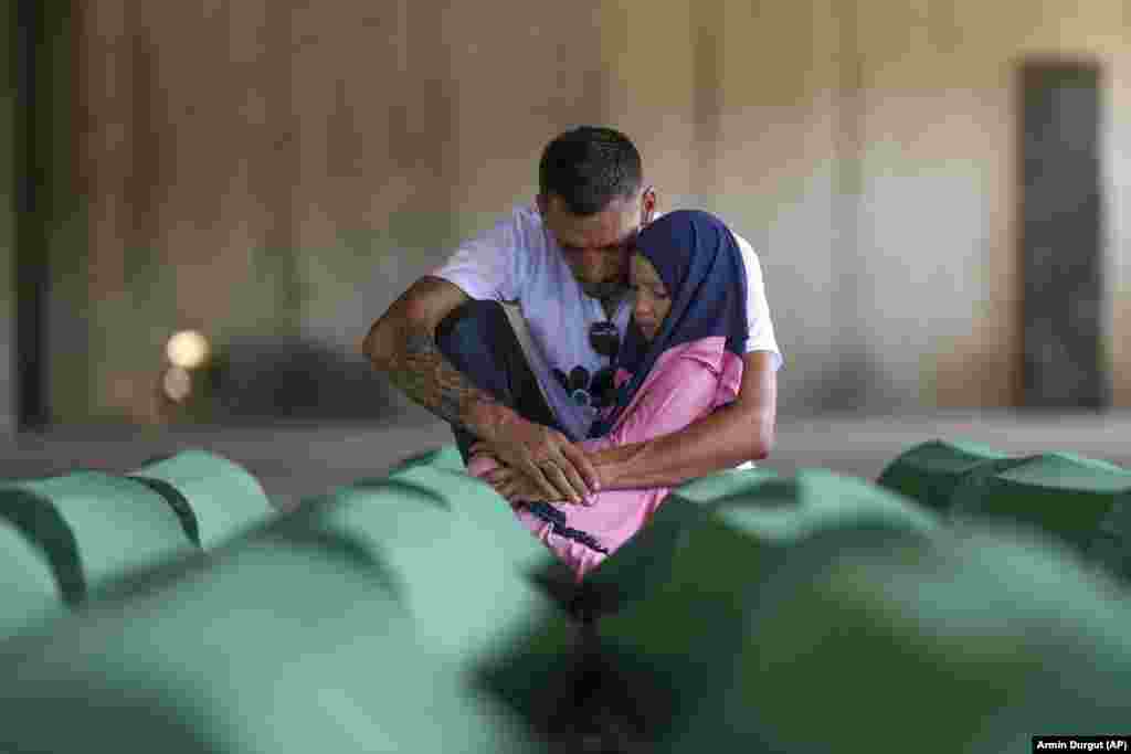 Samed Alic mourns with his daughter next to a coffin containing remains of his father, who was a victim of the Srebrenica genocide, in Potocari, Bosnia-Herzegovina, on July 10, ahead of the burial on July 11 of the remains of 30 recently identified victims of the massacre, Europe&#39;s only acknowledged genocide since World War II.