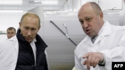 Businessman-turned mercenary leader Yevgeny Prigozhin (left) shows Russian Prime Minister Vladimir Putin his school lunch factory outside St. Petersburg in 2010.