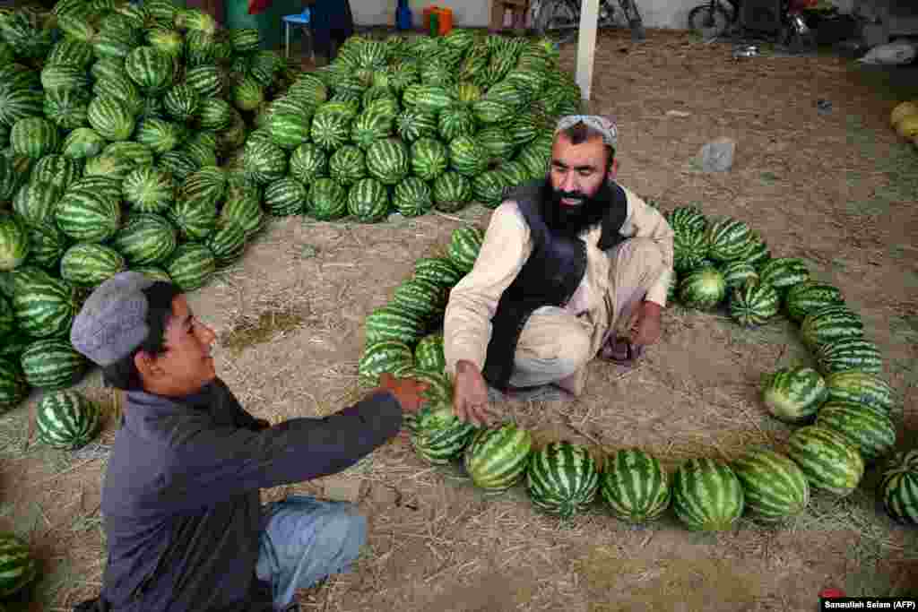 Vendors arrange watermelons as they wait for customers at a market in Kandahar, Afghanistan.