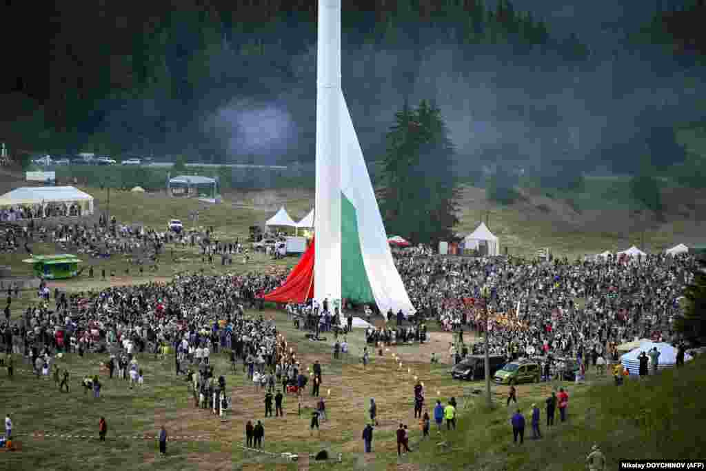 People watch the rising of a large Bulgarian flag during preparations ahead of the inauguration of an 111-meter (364-foot) flagpole in the Rozhen meadows near the city of Smolyan. The flagpole will be the tallest in the European Union, according to organizers.&nbsp;