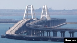 A train moves along the Crimea bridge, a section of which was damaged by an alleged attack the night before, on July 17.
