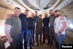 Zelenskiy, Chief of Staff of Presidential Office Andrew Yermak, and Interior Minister Ihor Klymenko pose with commanders of defenders of the Azovstal Iron and Steel Works in Mariupol on a plane en route to Ukraine from Istanbul after their release on July 8.