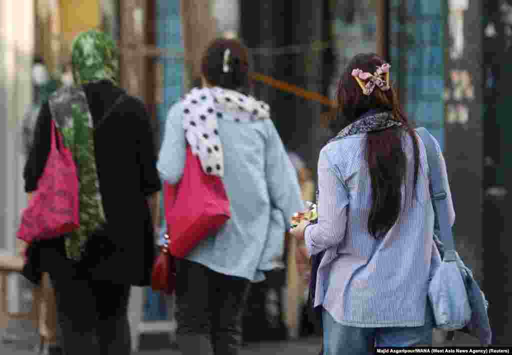 Women walking without head coverings in Tehran on July 16.&nbsp; Morality police were previously identifiable by the vans with a green stripe that used to transport arrested people, but recent footage from Iranian cities appear to show morality police now operating with unmarked white vans. &nbsp;
