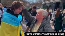 A teenage boy wrapped in the Ukrainian flag was one of the 31 Ukrainian children brought back to Ukraine by the Save Ukraine charity after they had been forcibly taken to Russia.