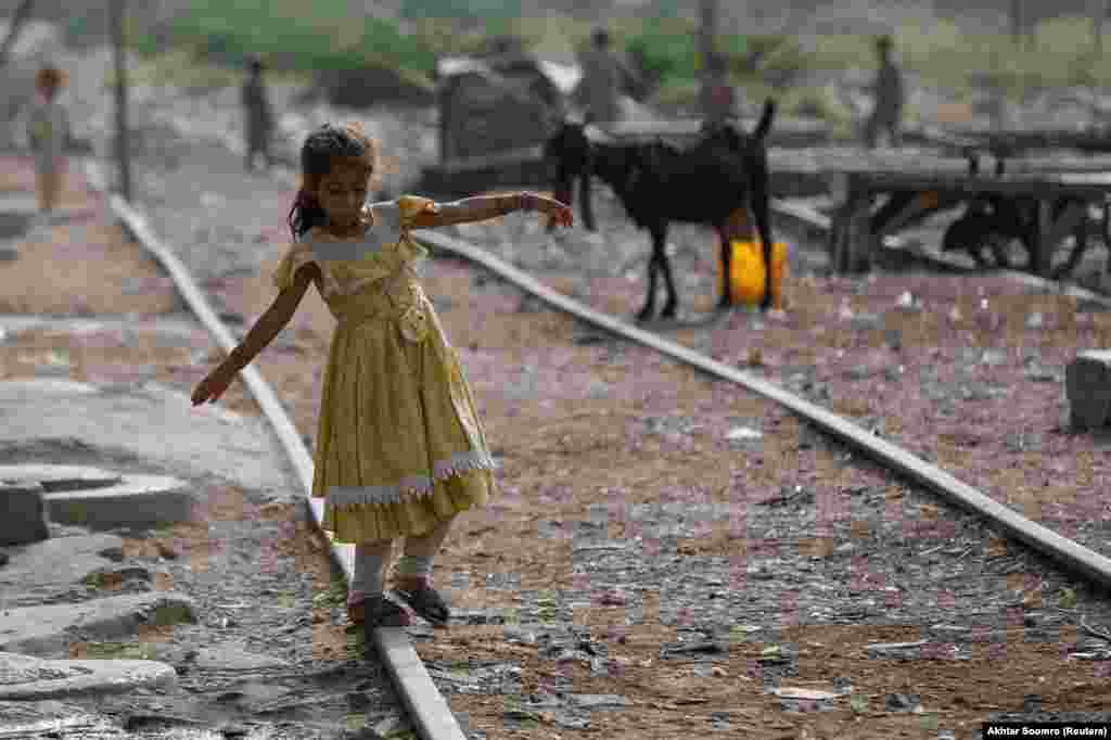 A girl walks along an abandoned railway track in a slum area of Karachi, Pakistan.