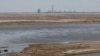 The view of the Russian-occupied Zaporizhzhya nuclear power plant from the Nikopol embankment across the Dnieper River reservoir, which is almost completely dried up following a dam breach downstream.