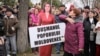 A woman slaps a cardboard cutout of Moldova's pro-Western President Maia Sandu, with a placard reading "Enemy of the Moldovan People," during a protest initiated by the populist Shor party, in Chisinau on November 13.
