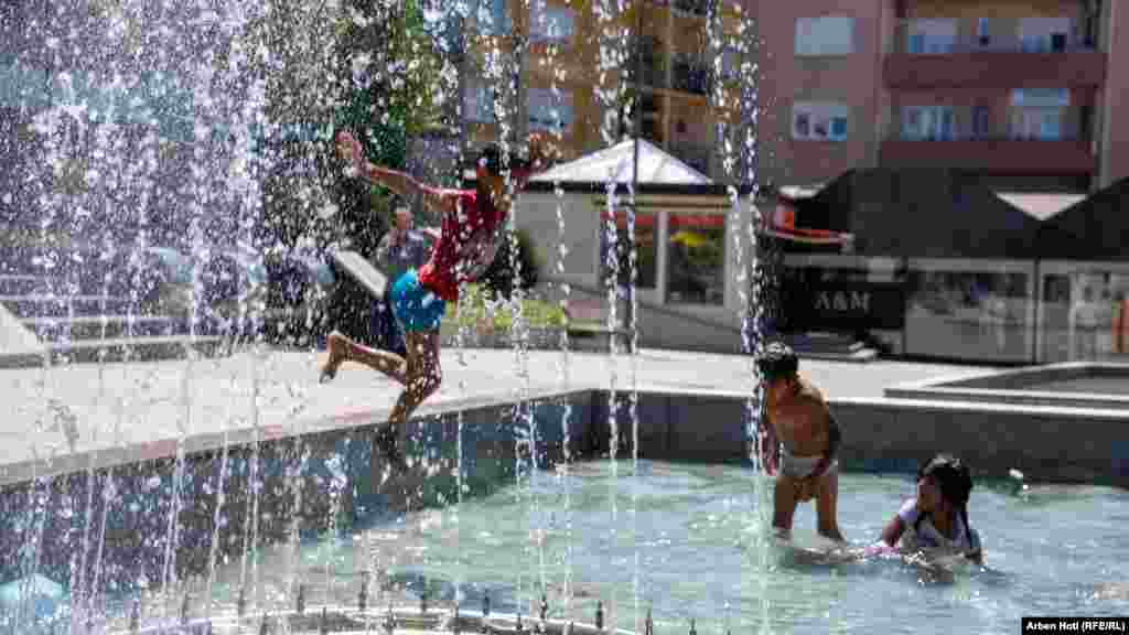 Kosovar children play in a fountain during a heat wave in Pristina.