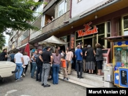 Residents of Stepanakert wait in line to buy bread at a bakery on July 18.