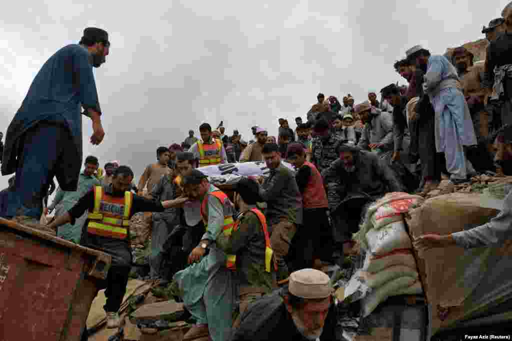 People carry the body of a victim killed in the landslide. Officials said more than 100 firefighters and rescuers were taking part in the operation to save truck drivers and other people who were trapped by the debris. &nbsp;