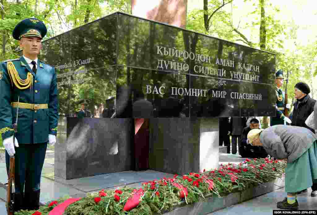 A Kyrgyz woman&nbsp;bows at the monument for the fallen liquidators in Bishkek.