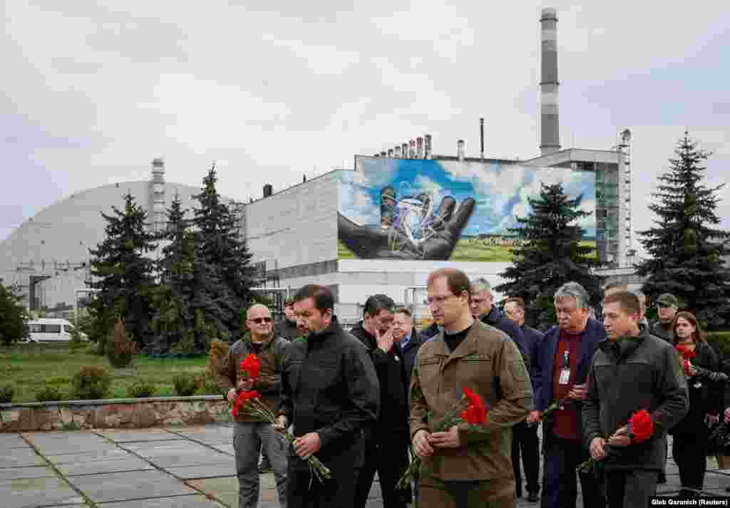 Ukrainian Ecology Minister Ruslan Strilets (center, wearing glasses) and other officials attend a memorial ceremony at the Chernobyl power plant on April 26 to mark the 37th anniversary of the world&#39;s worst civilian nuclear accident. The decommissioned plant was occupied by invading Russian forces for more than a month before they withdrew at the end of March 2022.