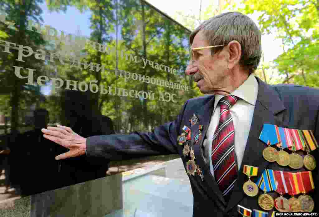 A former liquidator touches the monument to his fallen comrades in the Kyrgyz capital on April 26.
