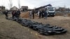 A view shows the bodies of civilians whom Ukrainian officials say were killed during Russia's invasion and then exhumed from a mass grave in the town of Bucha, outside Kyiv, on April 8, 2022.