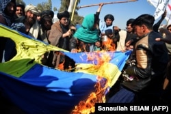 Protesters burn a Swedish flag during a demonstration against the burning of the Koran by Swedish-Danish far-right politician Rasmus Paludan in Kandahar on January 25.
