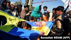 Protesters burn a Swedish flag during a demonstration in Kandahar on January 25. The demonstration followed the burning of a Koran by a far-right politician in Stockholm. In June, an Iraqi immigrant also burned a Koran outside a Stockholm mosque.
