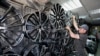 A salesman adjusts rims for wheels at the auto parts market in Moscow in June 2022. The International Monetary Fund predicts that the Russian economy is set to grow slightly in 2023, despite sweeping sanctions against firms and individuals. 