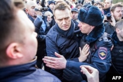 Police detain Kremlin critic Aleksei Navalny (center) during an anti-corruption rally in central Moscow on March 26, 2017.