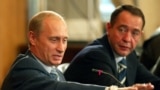 Mikhail Lesin (right), then Russia's press minister, listens as President Vladimir Putin speaks in 2002.