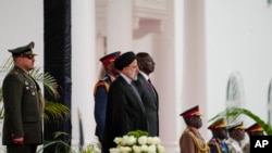 Iranian President Ebrahim Raisi (center-left) and Kenyan President William Ruto (center-right) stand for national anthems before meeting at the State House in Nairobi on July 12.