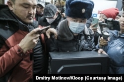 A police officer confiscates a computer from the Temirov LIVE office.