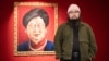 Badiucao poses next to his artwork Carrie Lam 2018, which merges the likeness of Chinese President Xi Jinping with that of Hong Kong leader, at his show in Brescia, Italy. “I wear these attempts at censorship as a badge of honor,” he says.