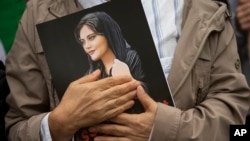 A demonstrator holds a portrait of Mahsa Amini during a rally calling for regime change in Iran following her death in September 2022.
